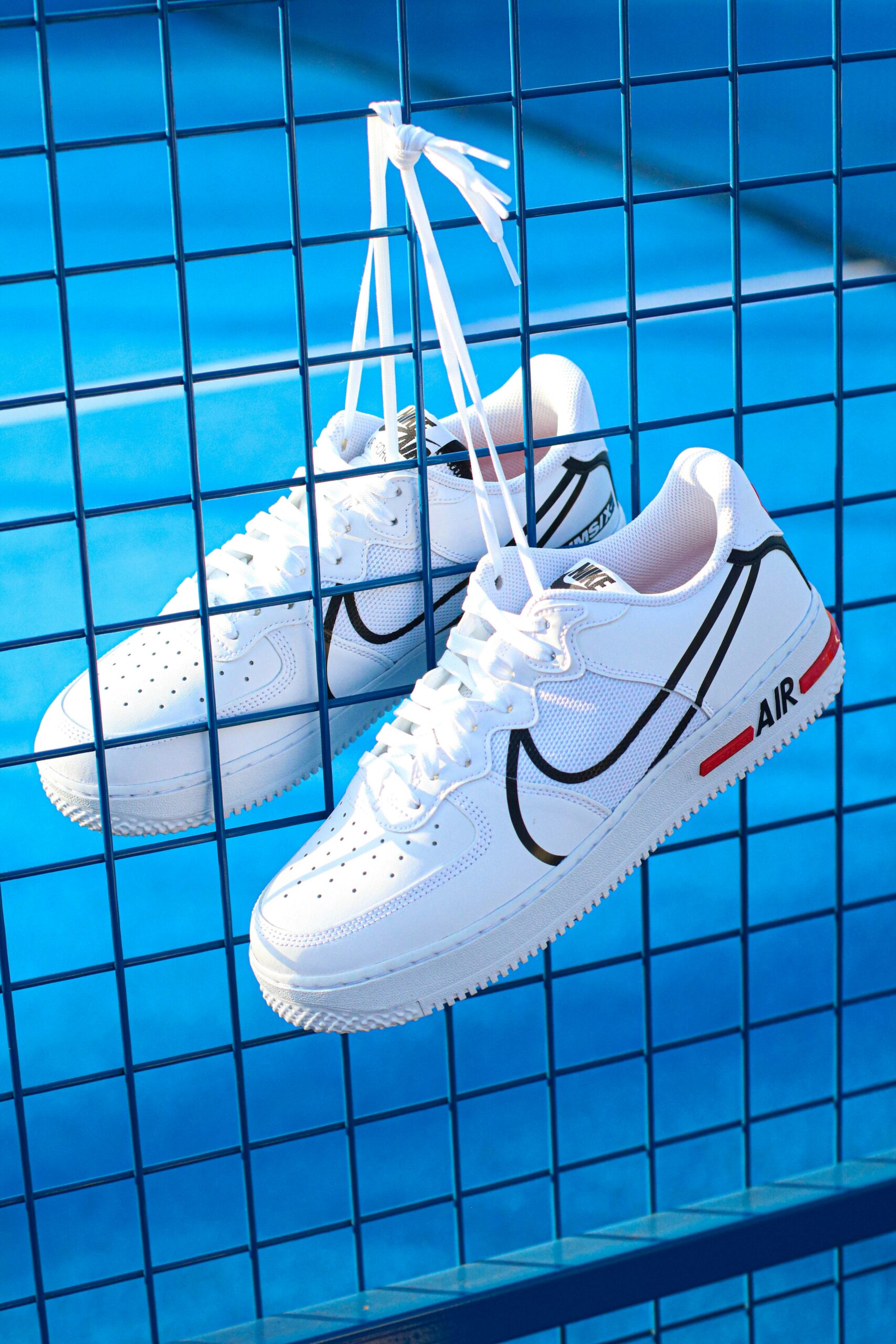 padelschoenen die hangen aan een padelnet